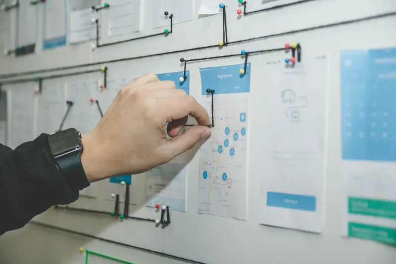 A hand mapping out a system diagram on a whiteboard